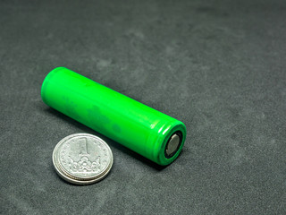 Green li-ion battery and small coins - selective focus