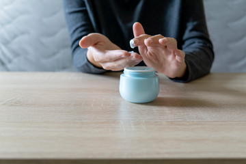 Woman doing the manicure. Removing the polish and putting on the cream. Woman that care his hands. Style concept.