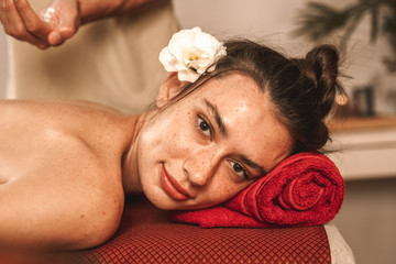 Obraz na płótnie Canvas Alternative Medicine. Therapist healing woman smiling happy doing abhyanga back massage with herbal oil