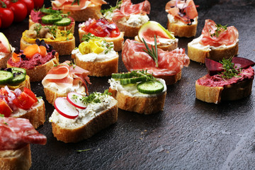 Assorted bruschetta with various toppings. Appetizing bruschetta or brie crostini. Variety of small sandwiches. Mix bruschetta on table