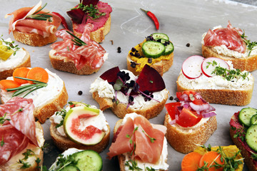 Assorted bruschetta with various toppings. Appetizing bruschetta or brie crostini. Variety of small sandwiches. Mix bruschetta on table