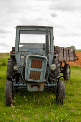 Obraz premium An old and battered tractor in the field