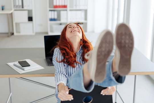 Laughing carefree woman having fun at the office