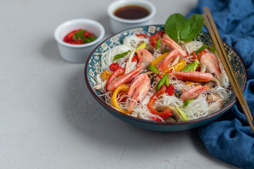 Oriental rice noodles Udon with sweet pepper, mushrooms and shrimp. Seafood.