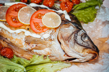 Baked stuffed fish carp with vegetables.