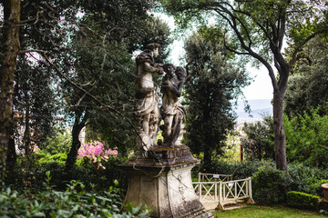 View of Boboli Gardens in Florence, Italy, with sculptures, blooming trees and flowers