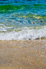 Detail of a wave of the sea on the shore of the sandy beach