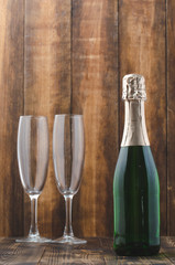 Bottle of sparkling wine and two glasses on a wooden background. Clebration background