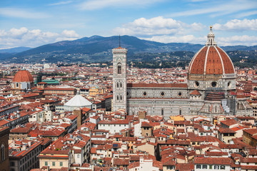 Fototapeta premium Beautiful super wide-angle aerial view of Florence, Italy with Florence Cathedral di Santa Maria del Fiore, mountains, skyline and scenery beyond the city, seen from the tower of Palazzo Vecchio