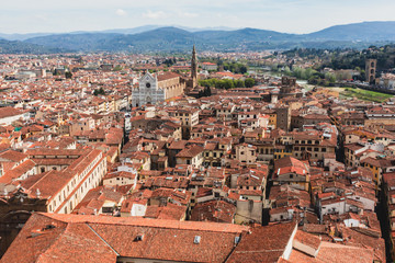 Beautiful super wide-angle aerial view of Florence, Italy with Florence Cathedral di Santa Maria del Fiore, mountains, skyline and scenery beyond the city, seen from the tower of Palazzo Vecchio