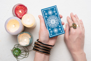 Fortune teller reading future on tarot cards over white table background.
