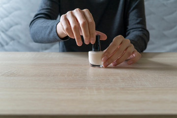 Woman doing the manicure. Removing the polish and putting on the cream. Woman that care his hands. Style concept.