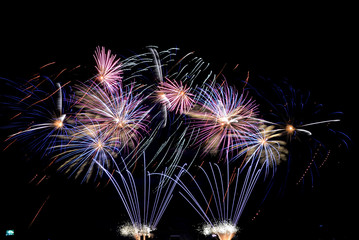 colorful fireworks of different colors lights and glitter on the night sky in summer