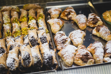 View of different traditional italian pastry candy desserts assorment, with cannoli, panna cotta, tartufo, amaretti, panettone, zeppole bomboloni, semifreddo, cartocci and others in Rome, Italy