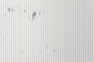 White corrugated wall with pealing paint makes nice textured background