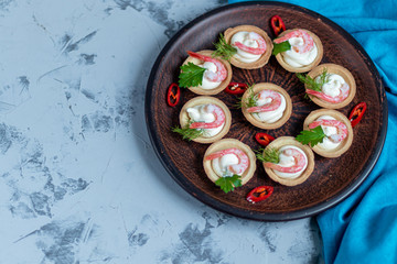 Tartlets with cream cheese and shrimp. Decorated with sprigs of dill and parsley.