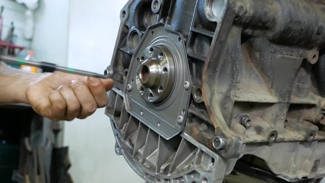 auto mechanic repairs car engine installs flywheel