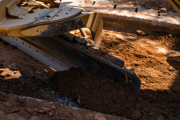 Fototapeta premium Details of grader is working on road construction. Grader industrial machine on construction of new roads. Heavy duty machinery working on highway. Construction equipment. Compaction of the road.