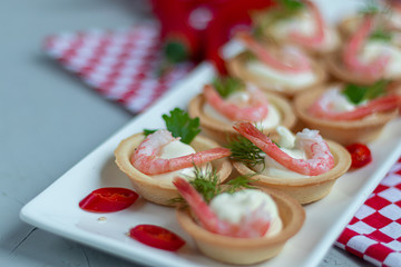 Tartlets with cream cheese and shrimp. Decorated with sprigs of dill and parsley.