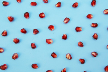 red pomegranate seeds isolated on background. Healthy fruits, vegan food, diet. Flat lay. Top view.