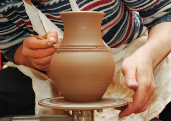 Hands of a Potter who makes a pot of clay close-up. Craft