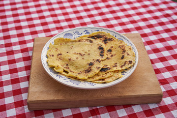 Traditional simple pancakes made from potatoes and dry fried in steel pan served on the rustic plate and wooden chopping board. Old and delicious side dish in Czech and Slovakian cuisine called lokse.
