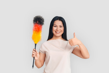 Freestyle. Asian woman standing isolated on white with duster showing thumb up positive