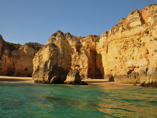 Fototapeta na wymiar Orange cliffs on the beachfront facing the emerald green sea
