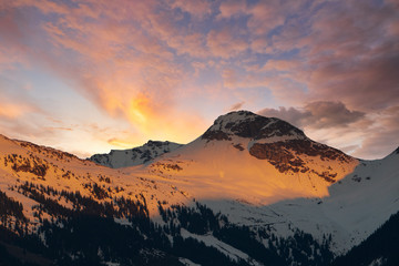 Naklejka na ściany i meble Sonnenuntergang mit mit schneebedeckten Bergen