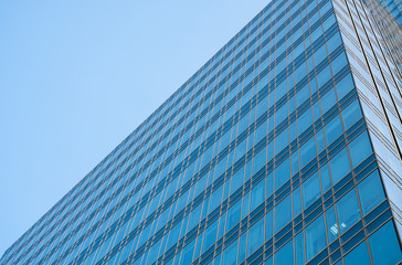 Fototapeta na wymiar Reflection of the sky in the windows of a building. Perspective and underdite angle view to modern glass building skyscrapers over blue sky. Windows of Bussiness office or corporate building.