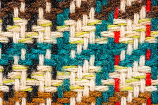 Brown checkered fabric with colored threads. Scottish wool. Fabric for plaid coat and suit. Close-up. Background