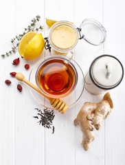 Fototapeta na wymiar Ginger tea with lemon honey Rose Hip and thyme at white wooden board in rustic style. Top view.