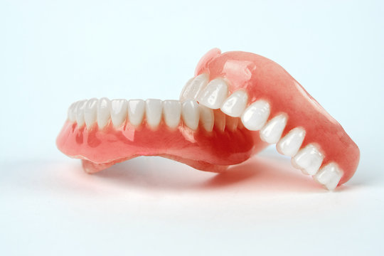 Diagnosis Prosthetics Treatment Concept. Artificial Teeth And Magnifying Glass