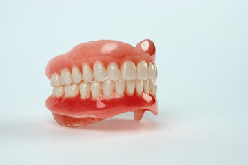 Diagnosis prosthetics treatment concept. Artificial teeth and magnifying glass