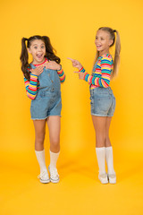 Fototapeta premium Best friends. Modern fashion. Kids fashion. Little girls wearing rainbow clothes. Happiness. Girls long hair. Cute children same outfits communicating. Trendy and fancy. Emotional kids. Fashion shop