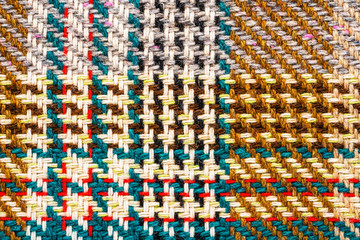 Brown checkered fabric with colored threads. Scottish wool. Fabric for plaid coat and suit. Close-up. Background