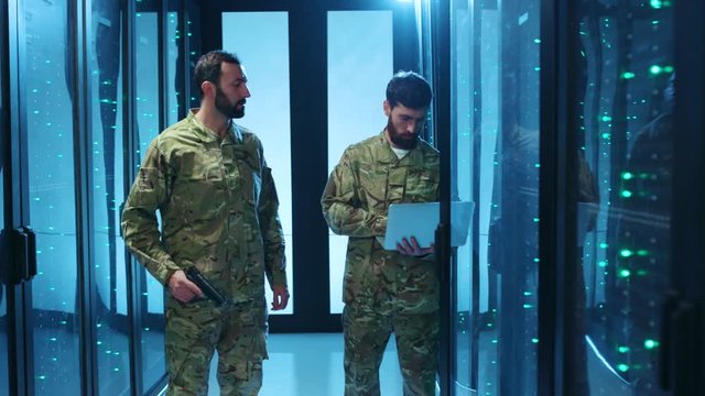 Security alarm in database. Two armed dangerous military men on spy mission intercepting web communications from server racks at data center. Espionage concept.