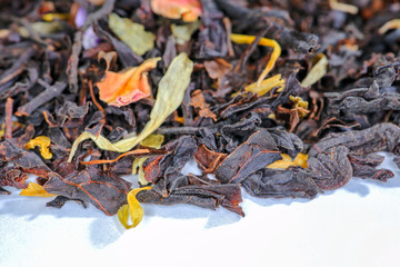black tea with fruit pieces and flower petals macro isolate
