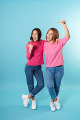 Full length of two happy young girls standing isolated