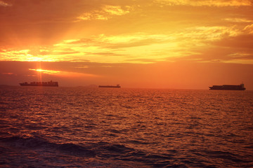 Romantic sunset over the Aegean sea with beautiful golden colours and clouds as seen from cruising yacht in Cyclades isalands, Greece