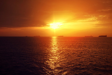 Romantic sunset over the Aegean sea with beautiful golden colours and clouds as seen from cruising yacht in Cyclades isalands, Greece