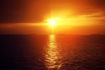 Romantic sunset over the Aegean sea with beautiful golden colours and clouds as seen from cruising yacht in Cyclades isalands, Greece