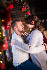 Portrait of a young couple in the living room at Christmas.