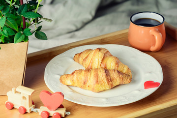 Coffee croissants, breakfast in bed. A romantic morning for your loved one.