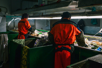 Worker at a waste processing plant. A man sorts rubbish with his hands. Sorting tape. The business...