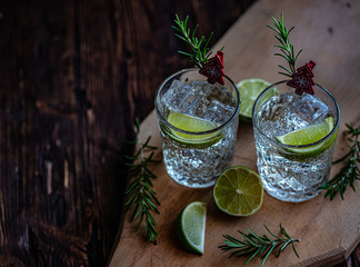 Ideas of winter drinks from gin and tonic for the new year. A bottle of gin and water tonic on a wooden table