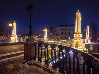 Fototapeta na wymiar Saint Petersburg. Russia. Bridges Of Petersburg. Rivers Of Petersburg. Christmas eve. The bridge is decorated for the New year. The fence of the bridge and pillars are covered with luminous garlands