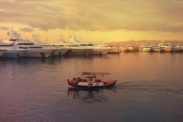 Fototapeta premium Beautiful sunset with golden colours and clouds in famous round port and marina of Zea or Passalimani, Piraeus, Attica, Greece