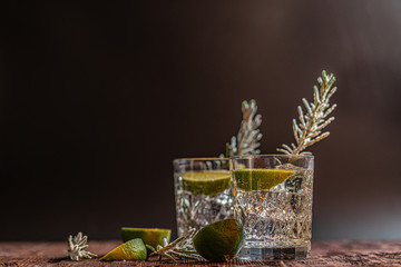 Gin and tonic with lime and ice on wooden table