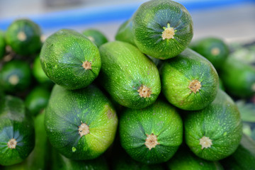 cucmbers stacked for sale at a farmers market.